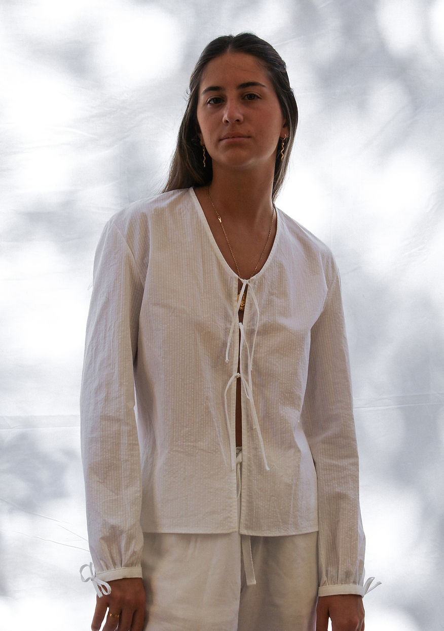 Blusa blanca texturizada con lazadas y mangas abullonadas
