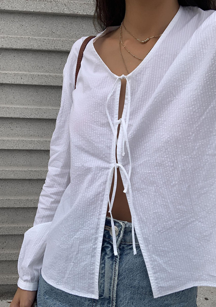 Blusa blanca texturizada con lazadas y mangas abullonadas