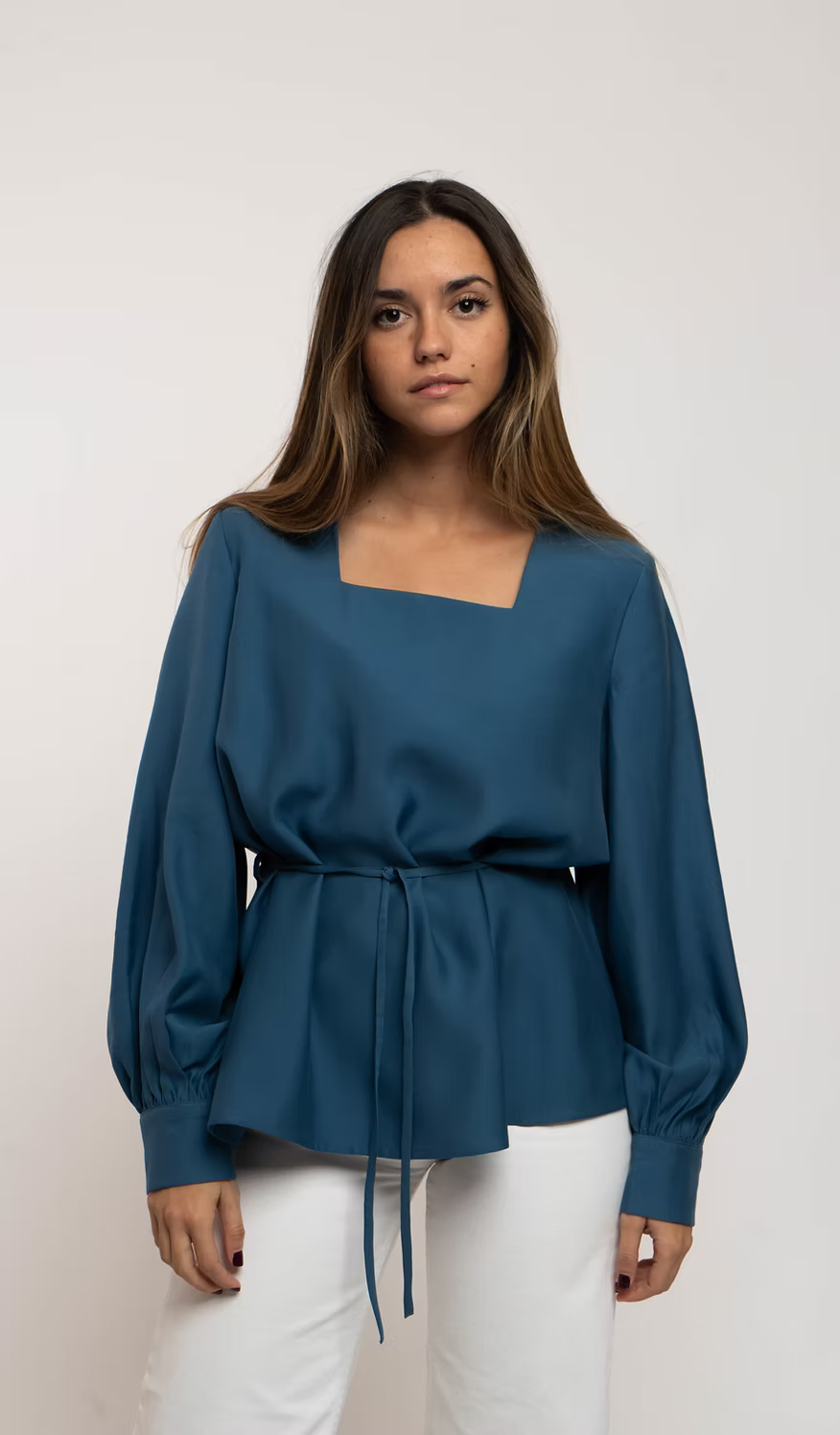 Blusa azul de escote cuadrado con mangas abullonadas, puños abotonados y cintura entallada con lazada
