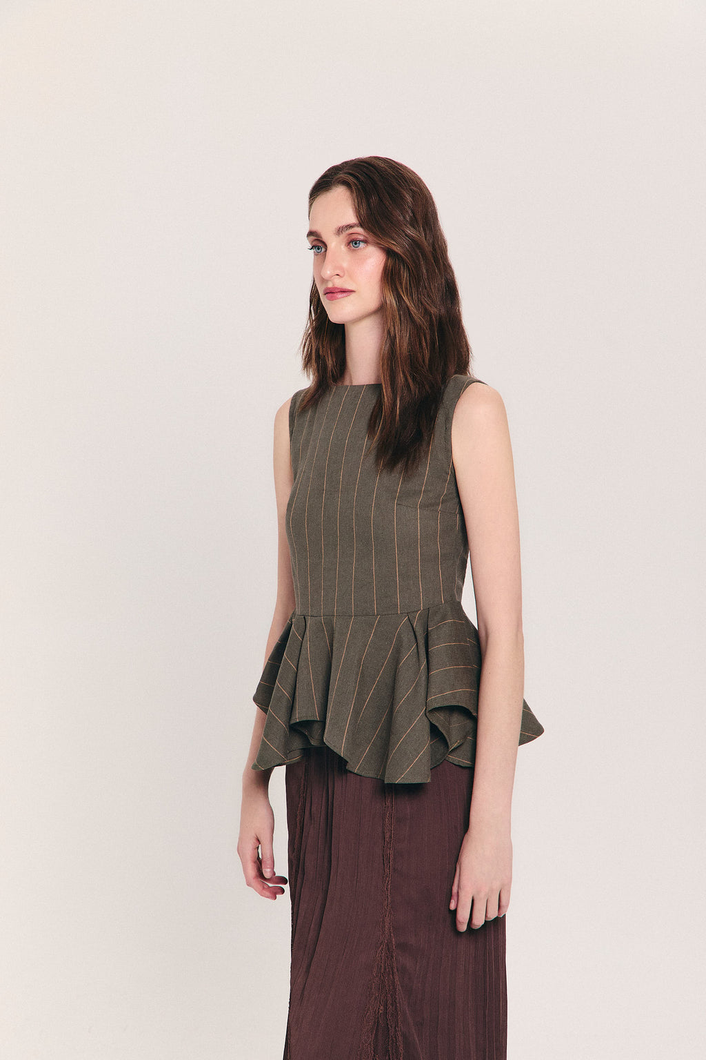 Blusa verde sin mangas de raya diplomática con peplum asimétrico en cintura