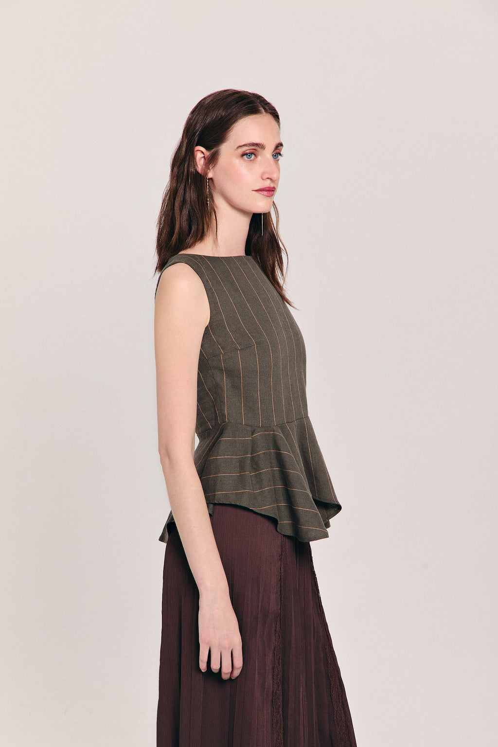 Blusa verde sin mangas de raya diplomática con peplum asimétrico en cintura