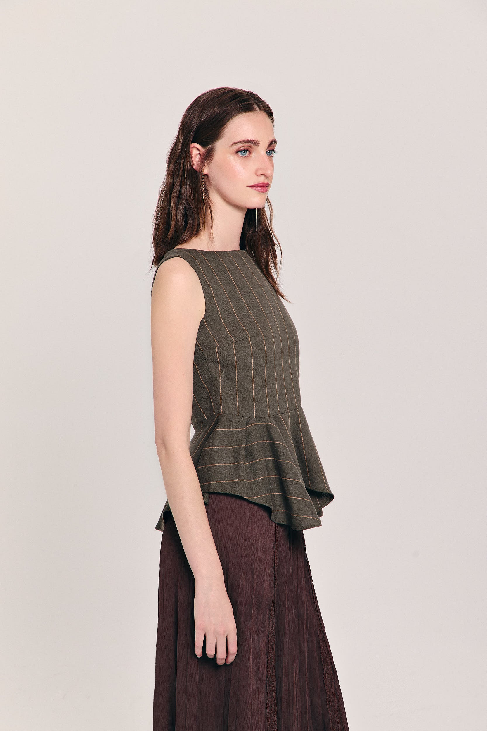Blusa verde sin mangas de raya diplomática con peplum asimétrico en cintura