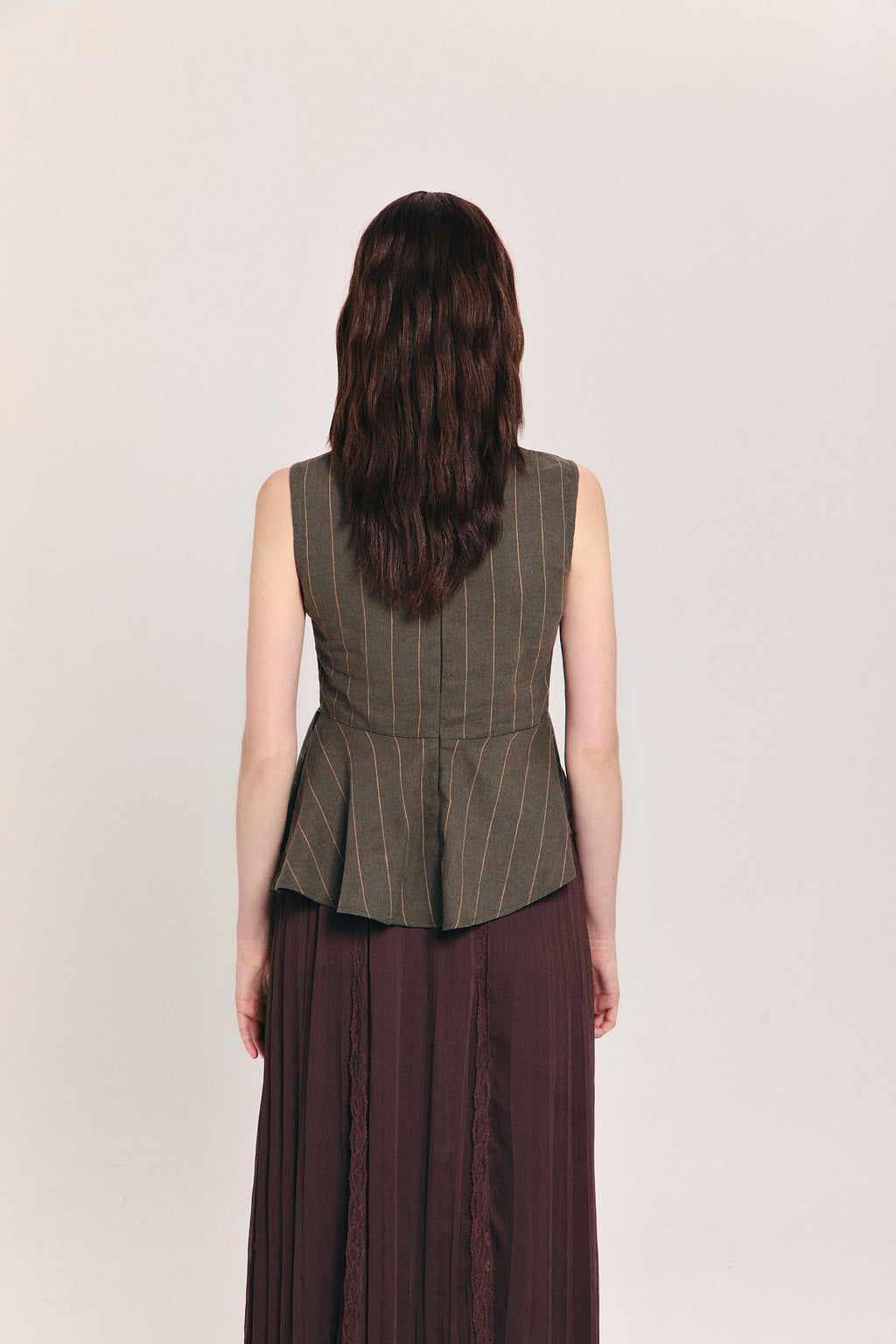 Blusa verde sin mangas de raya diplomática con peplum asimétrico en cintura