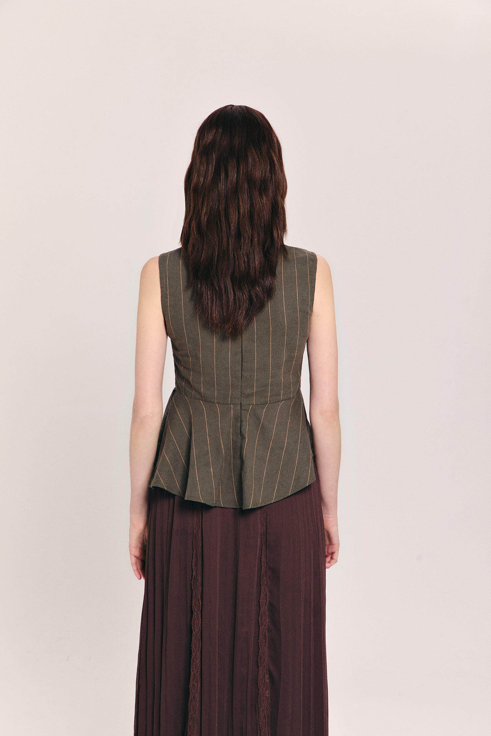 Blusa verde sin mangas de raya diplomática con peplum asimétrico en cintura