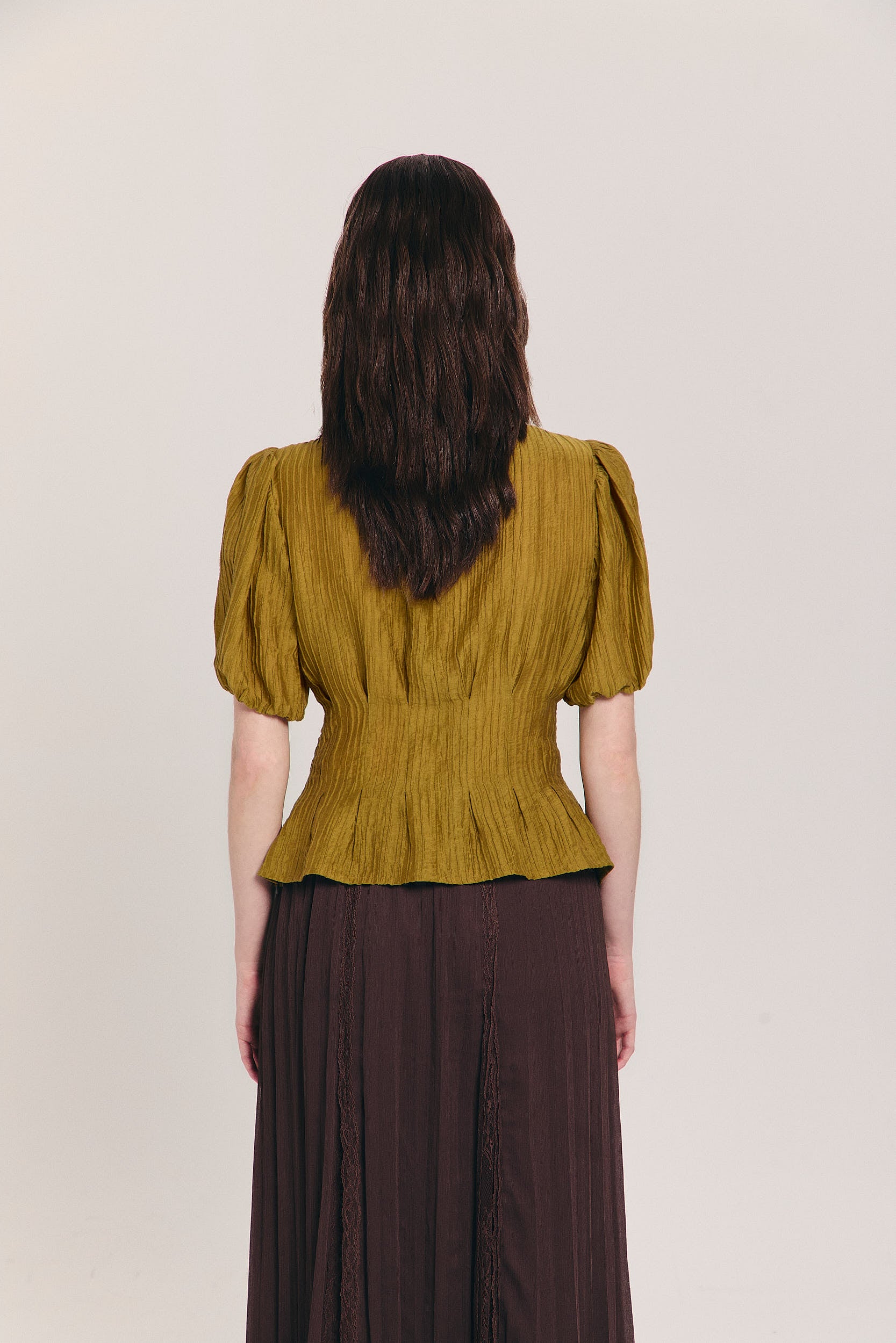 Blusa plisada ocre con mangas abullonadas globo y cintura entallada